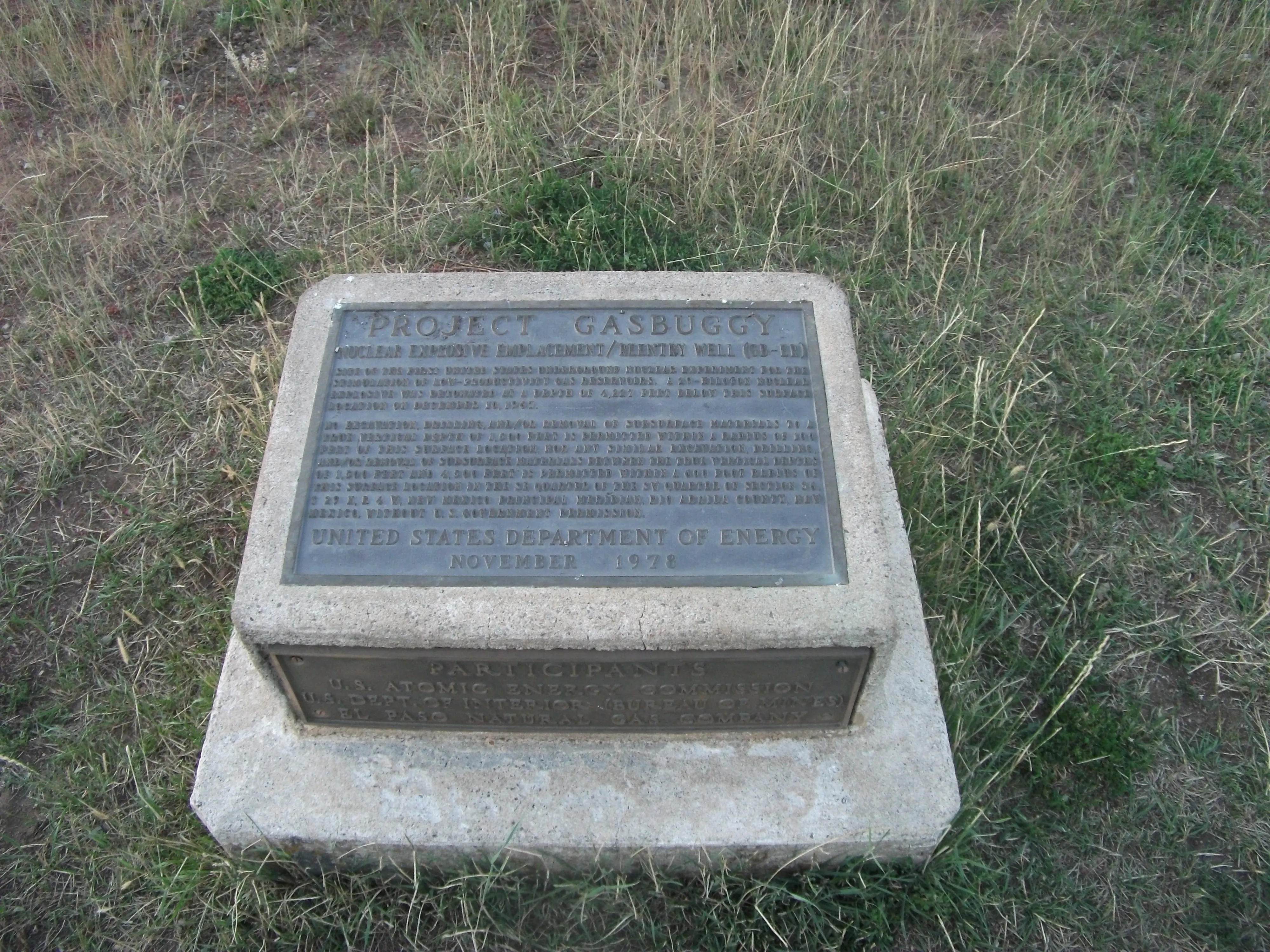 Bronze Project Gasbuggy plaque on a concrete monument in grass, Carson National Forest