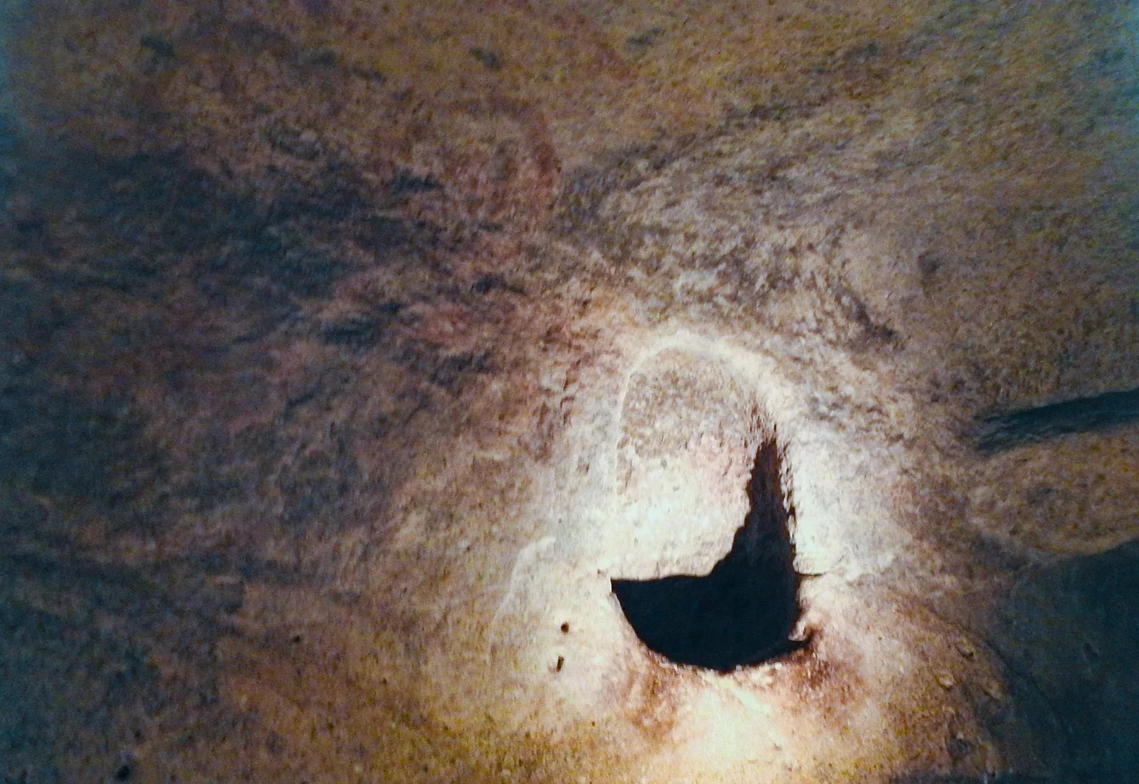 The Oracle Chamber niche in the Ħal Saflieni Hypogeum, Malta - a small carved hole in painted limestone